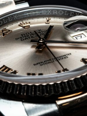 Detailed close-up of a luxury Rolex wristwatch displaying its elegant design and date feature.